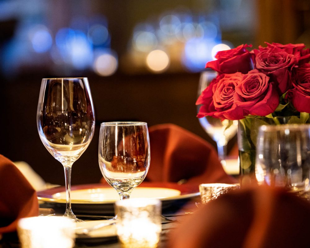 Wine glasses with roses on a dining table