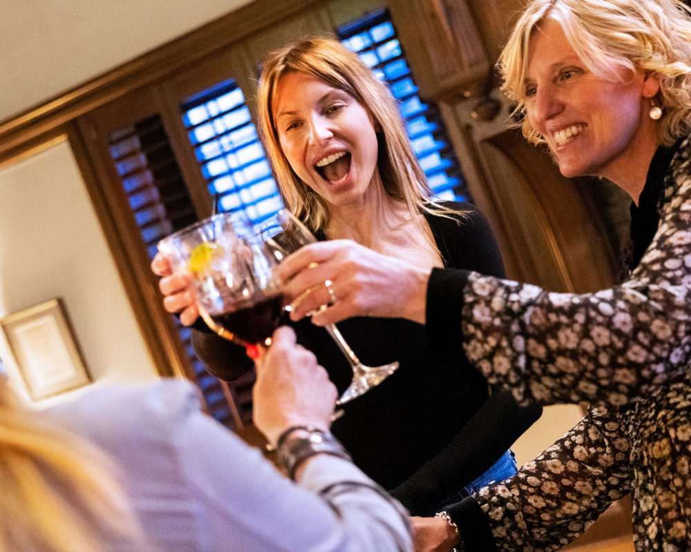 Women joining wine glasses jubilantly