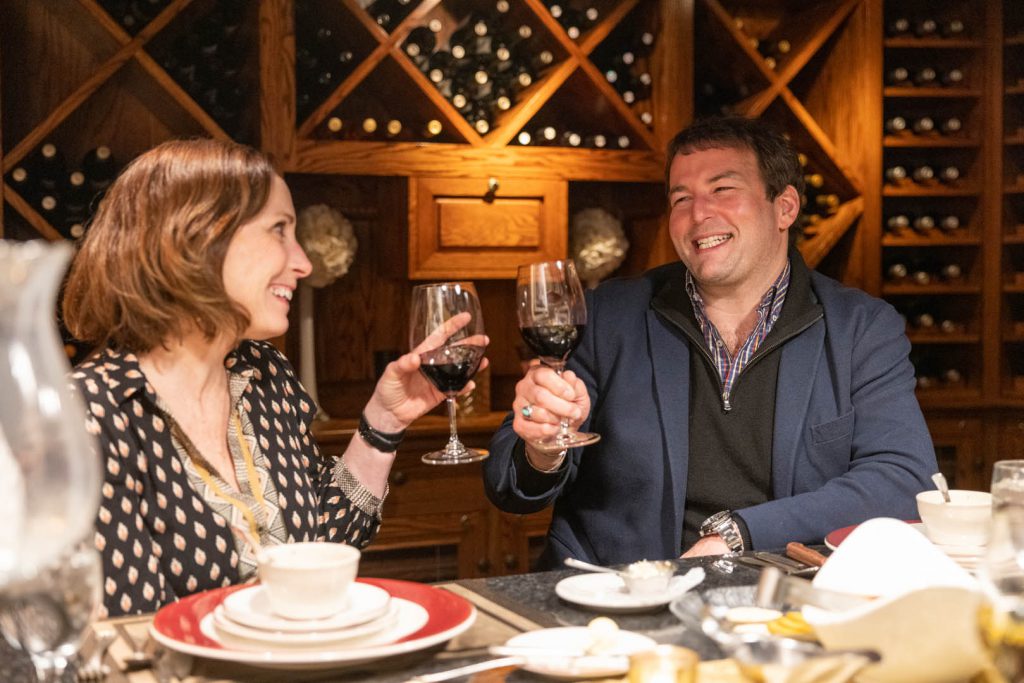 couple toasting while eating in the wine cellar