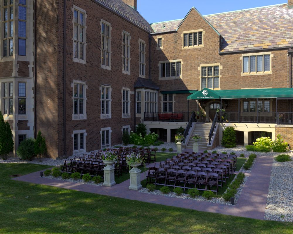 The Kitchi Gammi Club's brick exterior and east garden, set for an outdoor ceremony